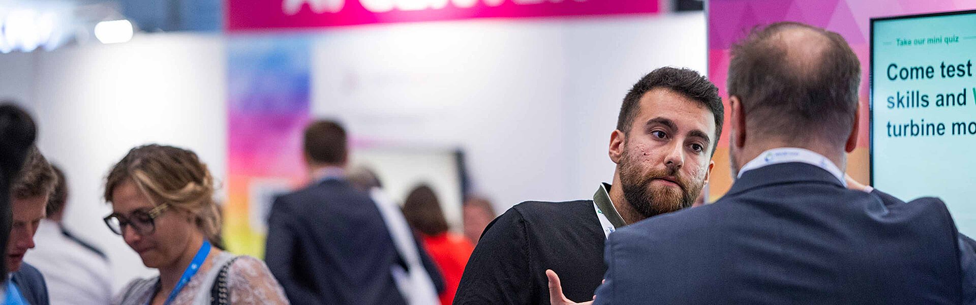 Personen unterhalten sich am AI Center der WindEnergy Hamburg 2024.