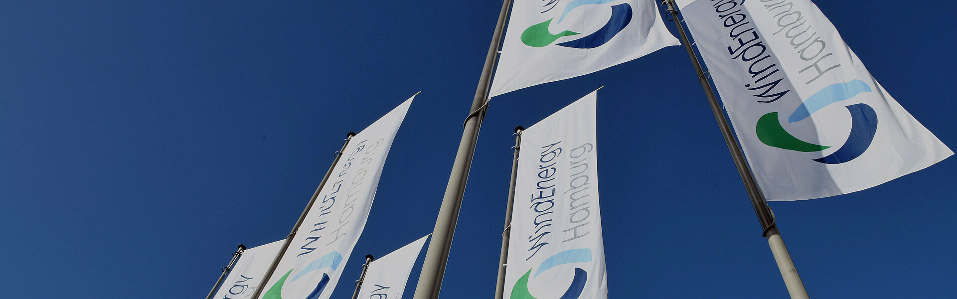 Flaggen der WindEnergy Hamburg vor blauem Himmel
