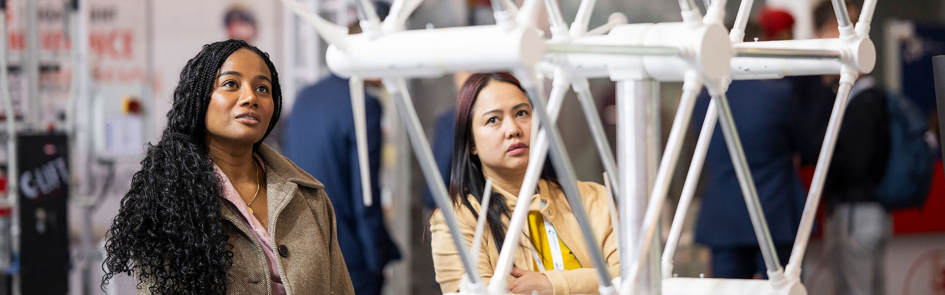 Zwei Frauen betrachten ein Ausstellungsstück auf der WindEnergy Hamburg.